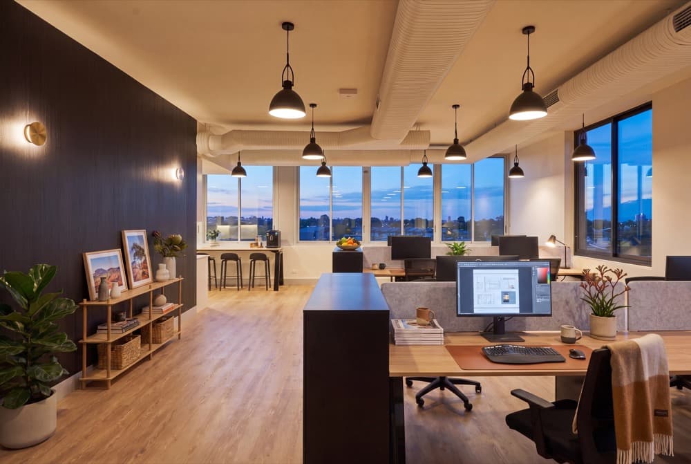 An open plan floor virtually staged at dusk with furniture and lighting